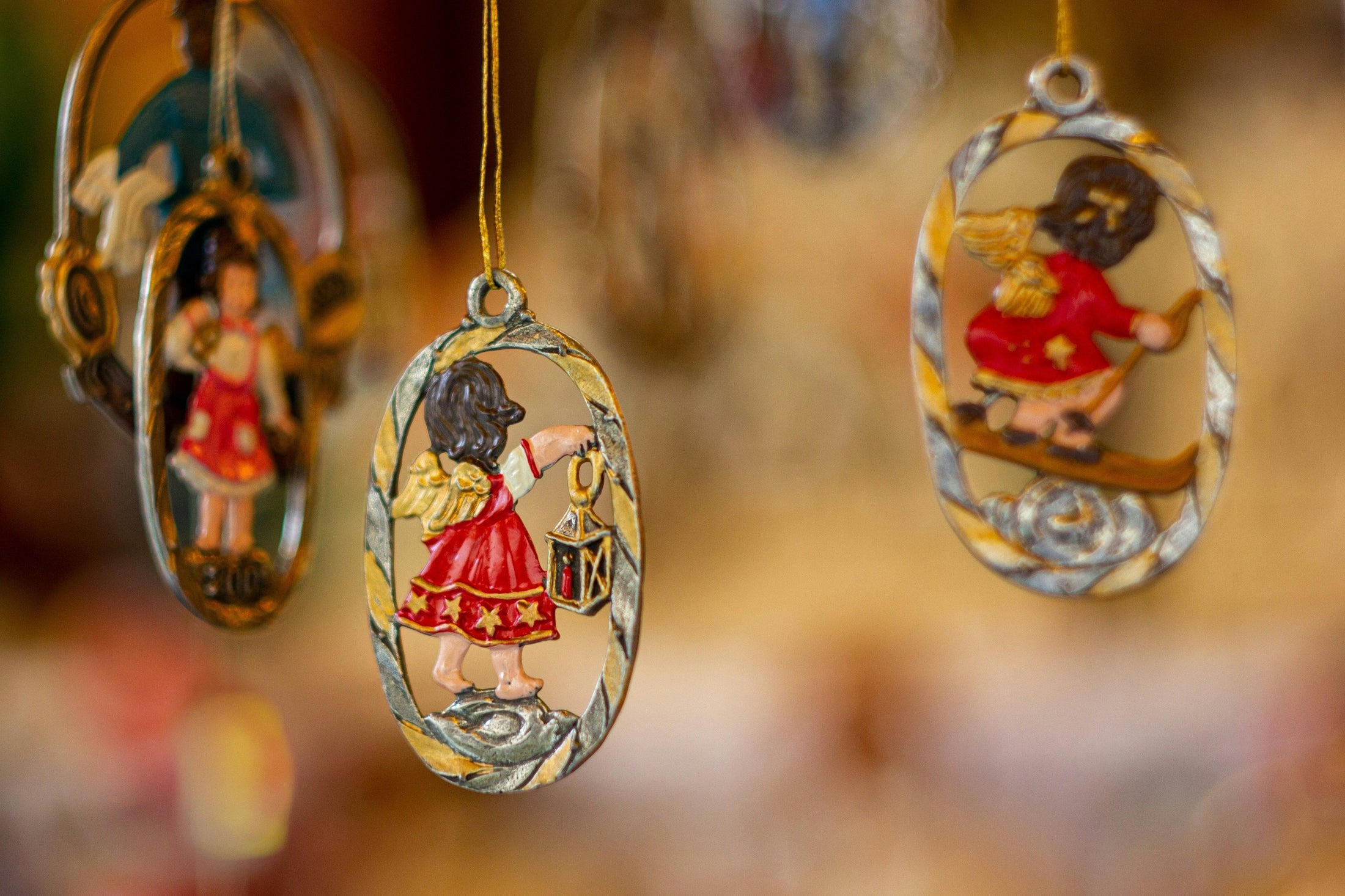 Decorative oval holiday ornaments with hand-painted figures hanging on gold ribbons, wholesale sublimation ornament blanks for personalized Christmas gifts from Photo USA