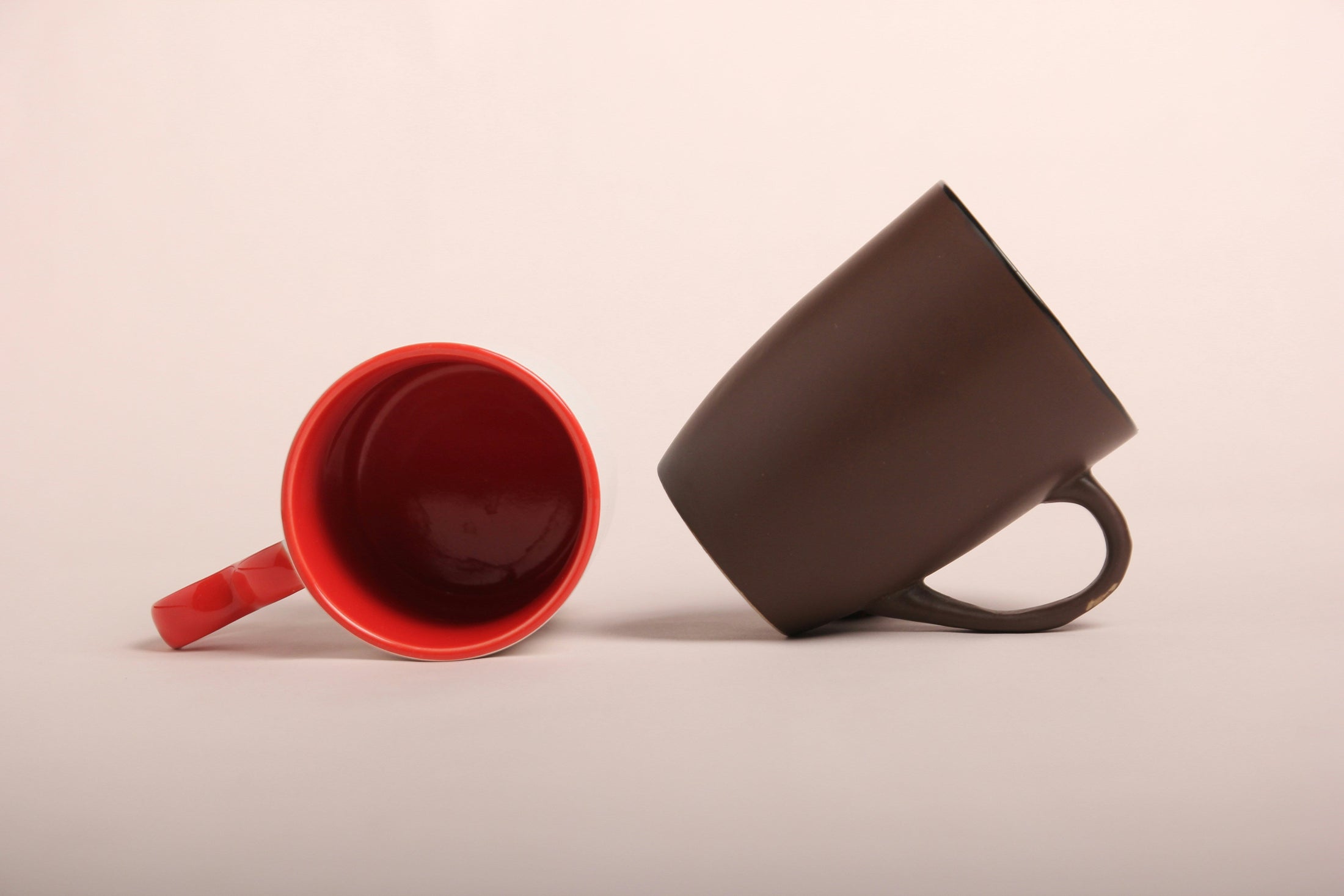 Two color changing sublimation mug blanks, one red and one brown, wholesale color changing mugs by the case from Photo USA Corp.