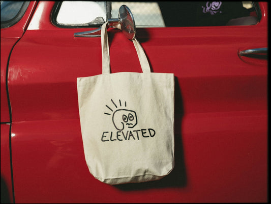 Custom printed canvas tote bag hanging on a red car door, sublimation tote bags for custom print shops and bulk group orders.